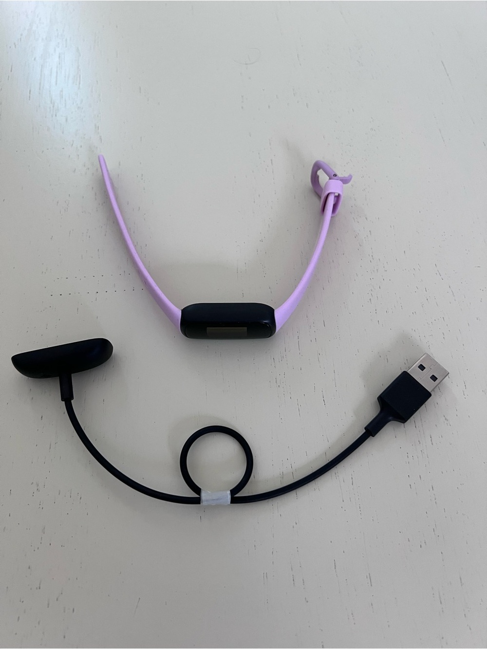 fitbit lavender and black fitness tracker with charger